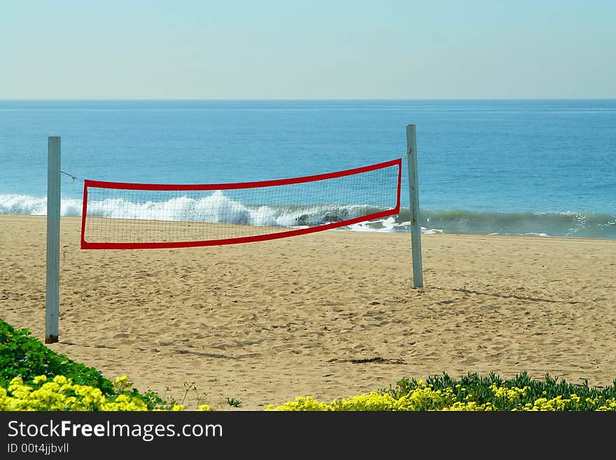 A beach volleyball net on the beach at the ocean. A beach volleyball net on the beach at the ocean