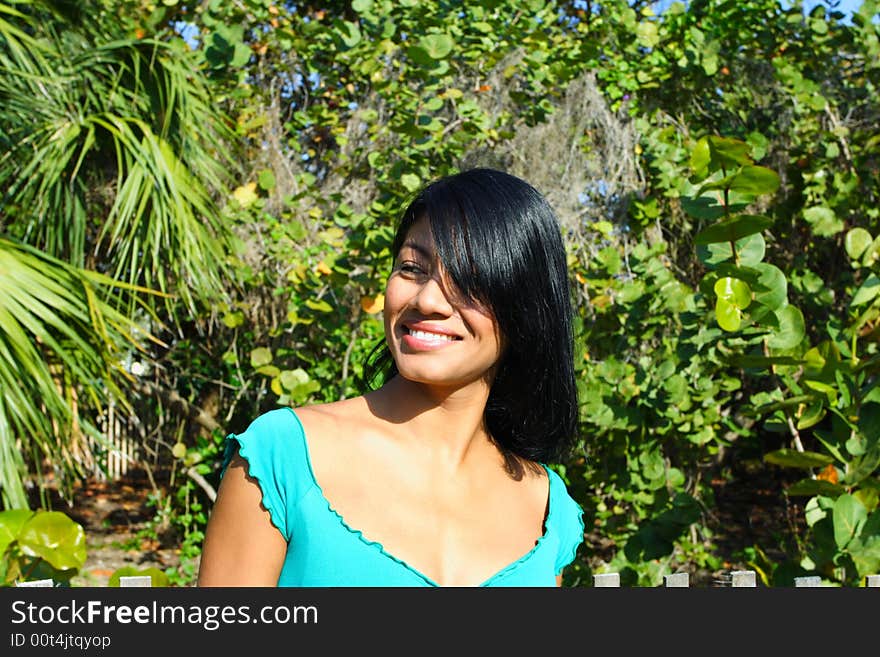 Attractive Woman Smiling with greenery in the Background. Attractive Woman Smiling with greenery in the Background.