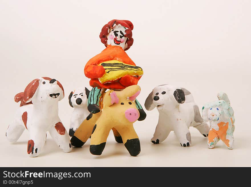 Painted clay figures of a balalaika player on pig and four dogs. Painted clay figures of a balalaika player on pig and four dogs