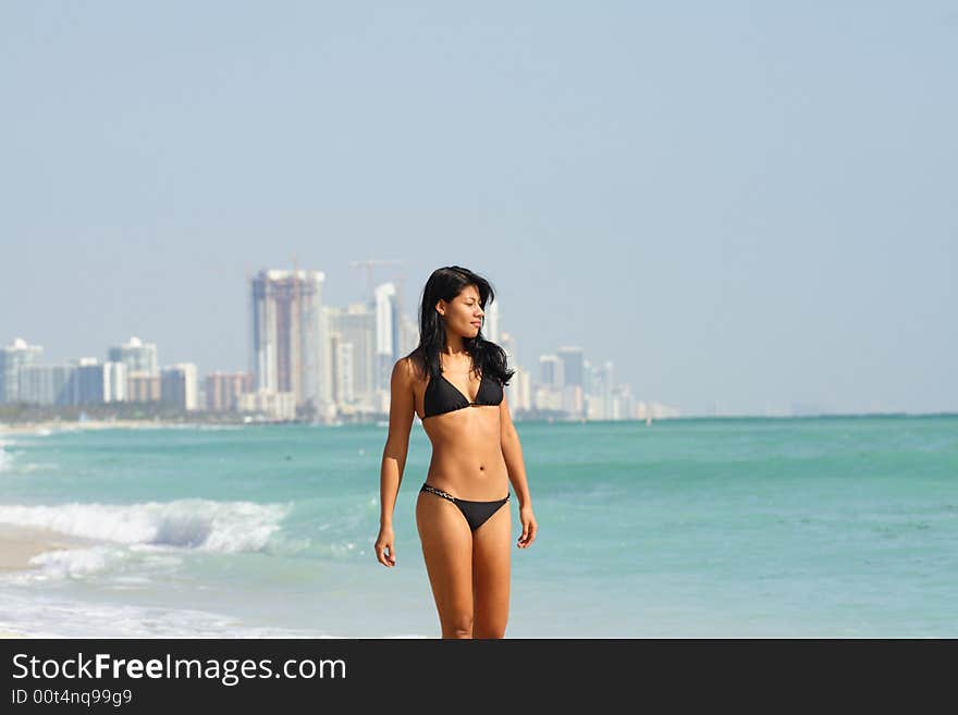 Woman walking near the ocean shore. Woman walking near the ocean shore.