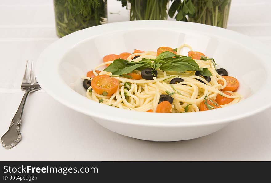 Close up a spaghetti with tomatoes and olives