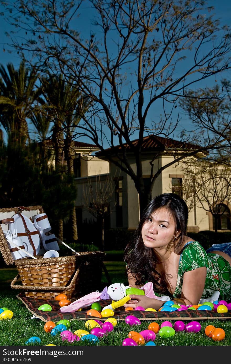 Asian female with a sad face as she is left stranded at her picnic area with easter eggs everywhere. Asian female with a sad face as she is left stranded at her picnic area with easter eggs everywhere.