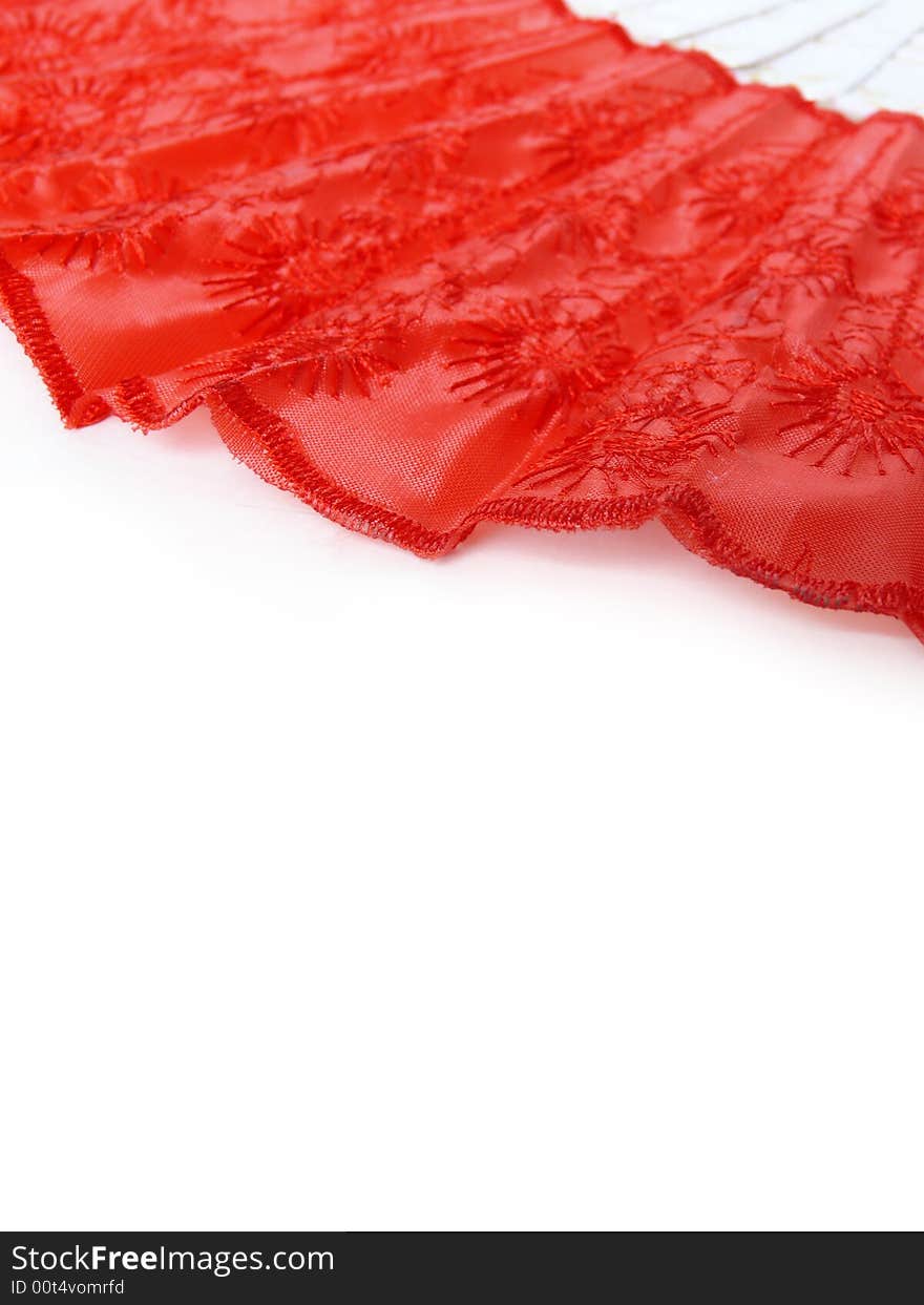 Part of red fan lying on white surface. Abstract red and white background. Part of red fan lying on white surface. Abstract red and white background.