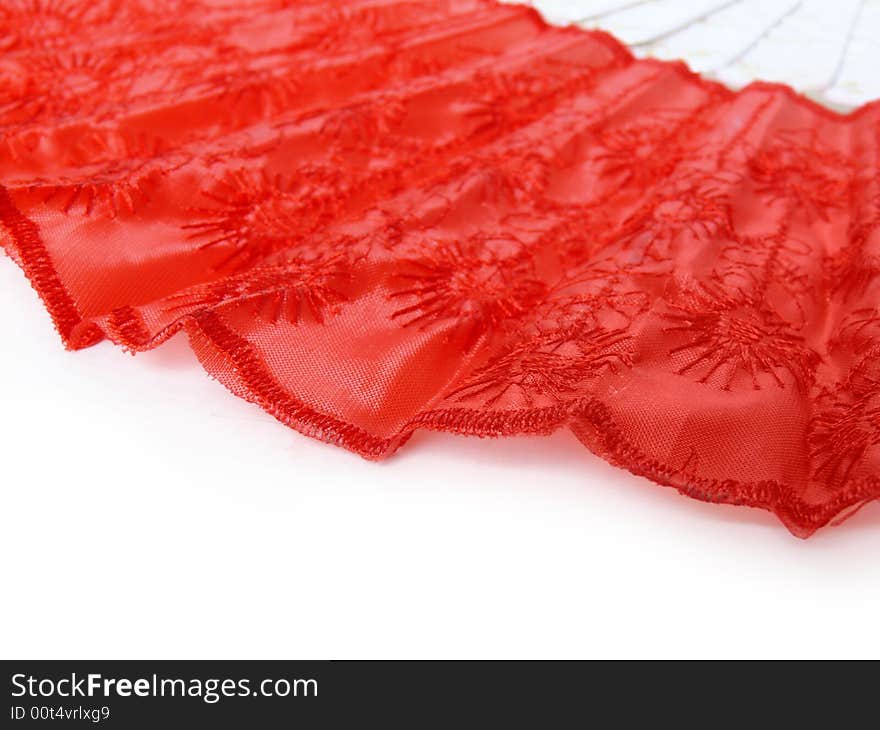 Part of red fan lying on white surface. Abstract red and white background. Part of red fan lying on white surface. Abstract red and white background.