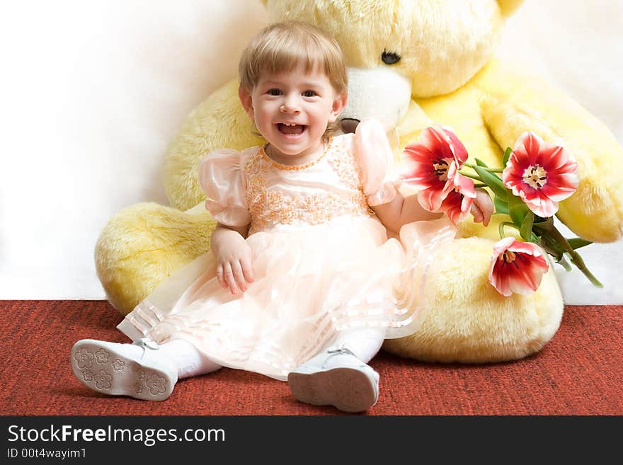 Cute little girl with tulips and teddy bear