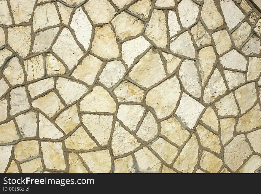 Ancient wall of white rough stones in the warm light of the early morning