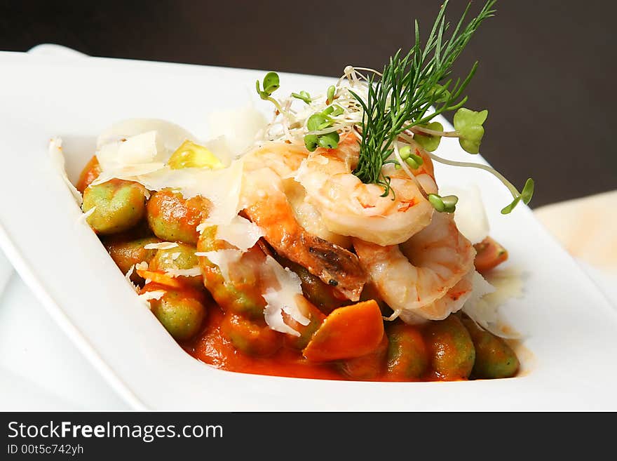 Four shrimps with caper and artichoke on the table