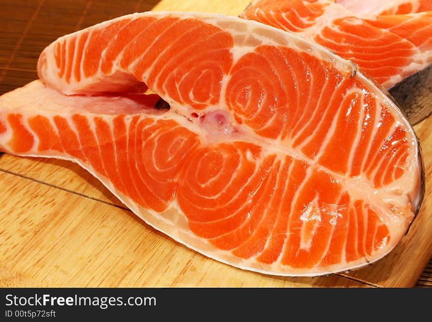 Succulent fresh piece of a salmon on a wooden board