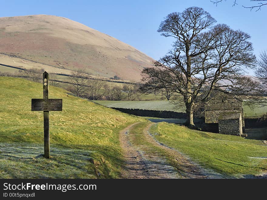 Footpath sign, tree and barn