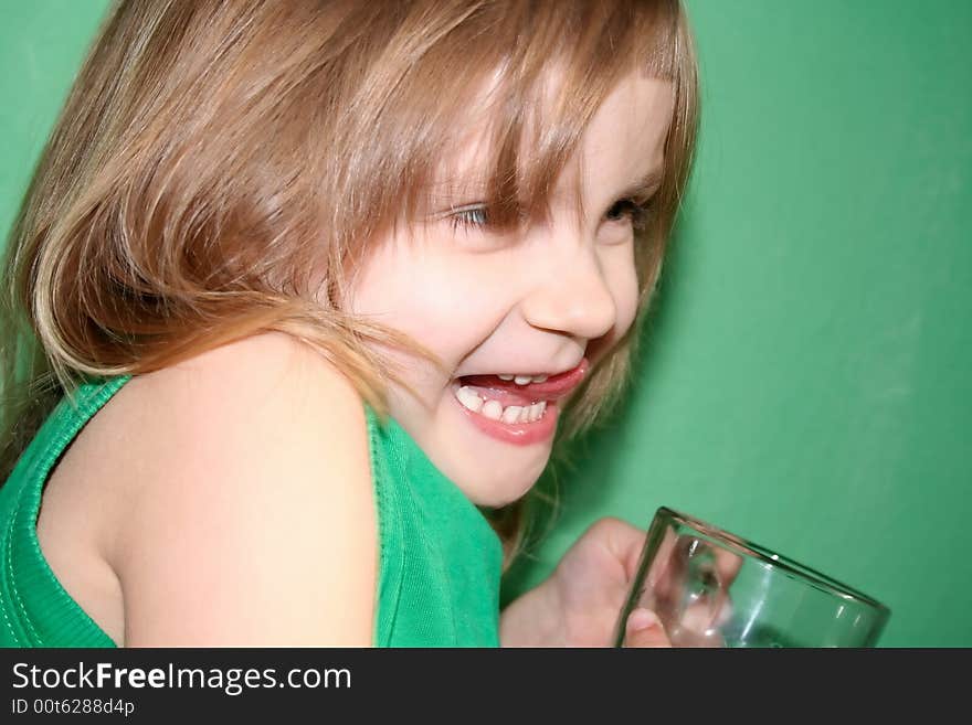 Laughing girl with a cup on green background