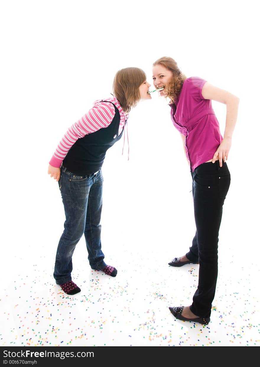 The two girls with a sugar candy isolated on a white background