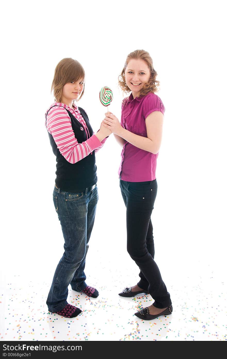 The two girls with a sugar candy isolated on a white background