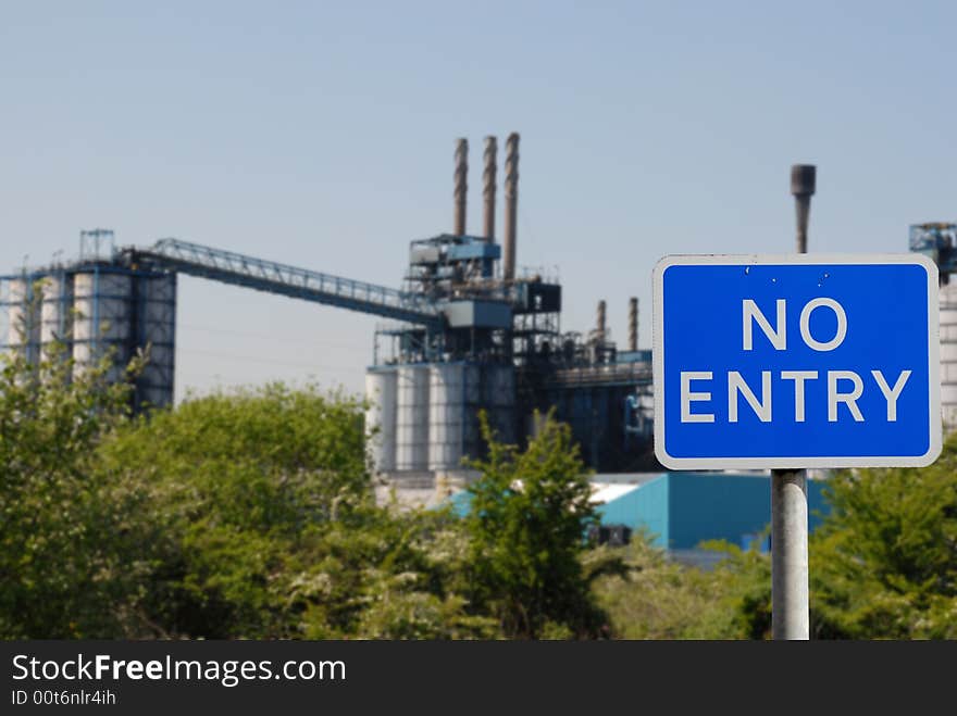 No entry sign with an industrial scene in the background