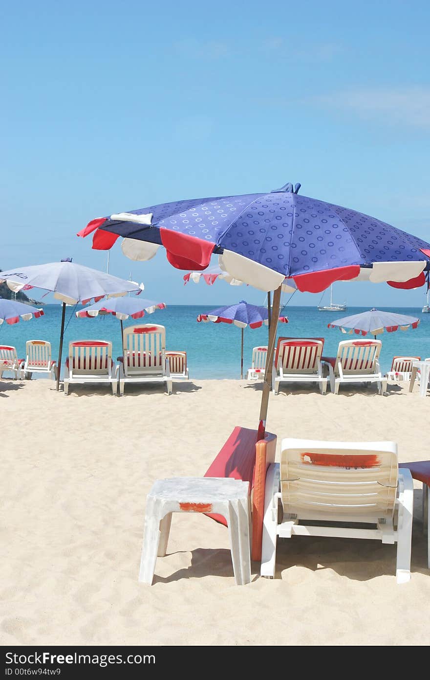 Rows of colorful beach chairs and umbrellas at the beach.