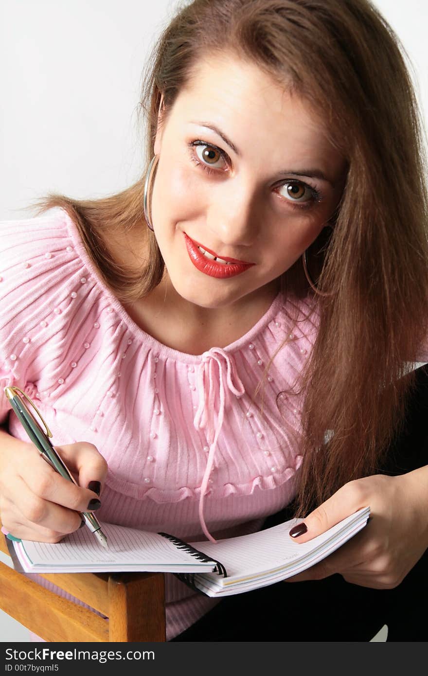 Young woman is writing something and thinking 
(See also my other pics). Young woman is writing something and thinking 
(See also my other pics)