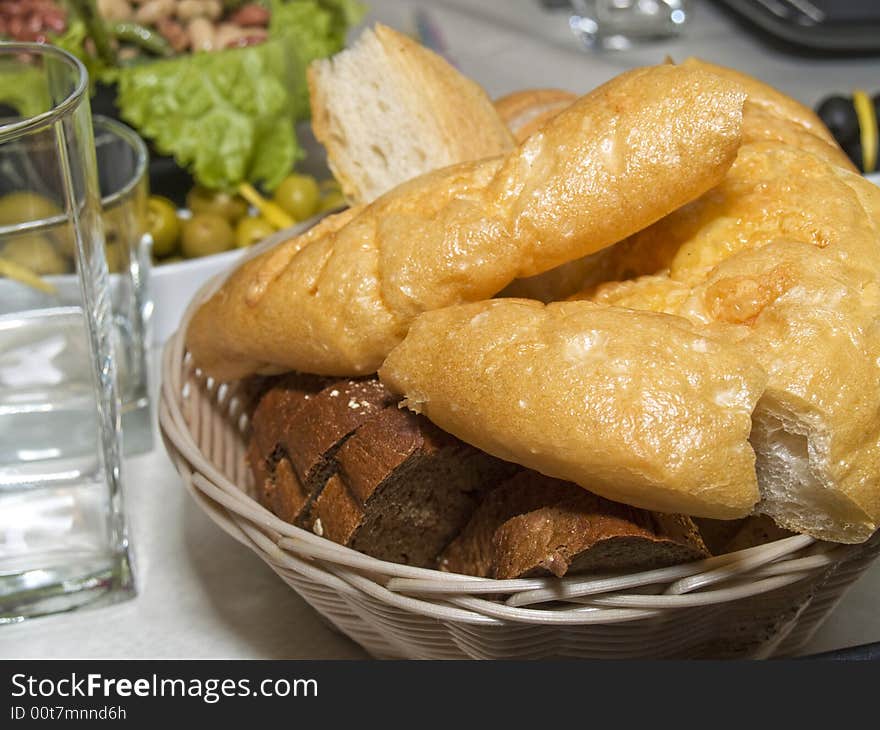 Pieces of different sort of bread and Italian chiabatta in biscuit dish on the served table