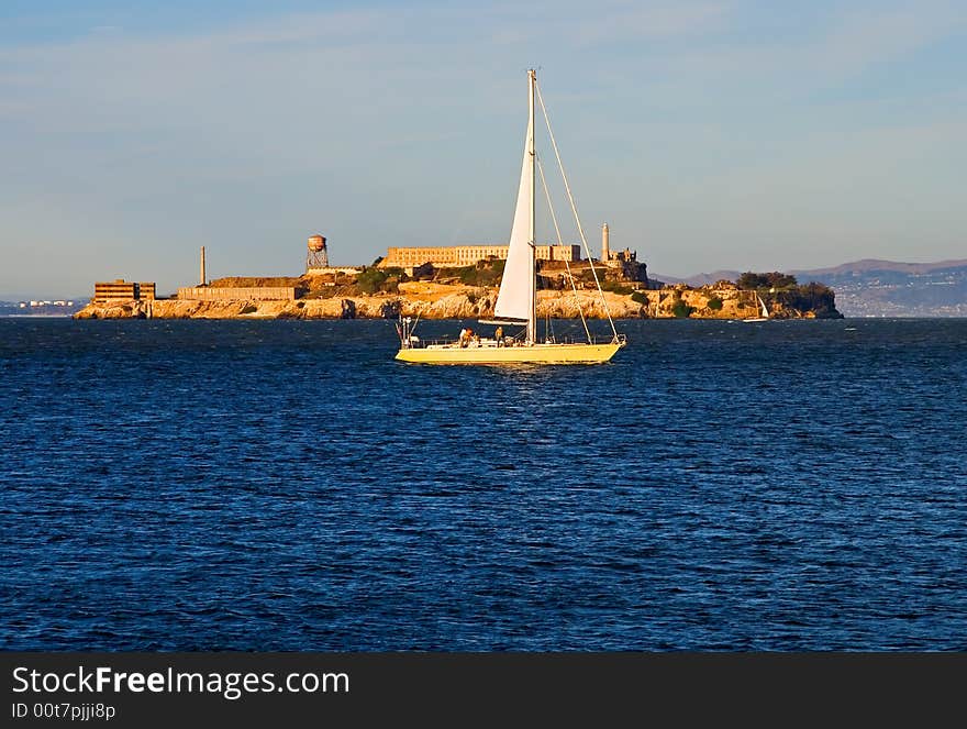 Sail boat next to Alcatraz island at sunset