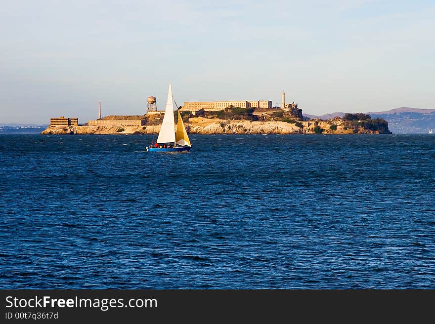 Sail boat next to Alcatraz island at sunset