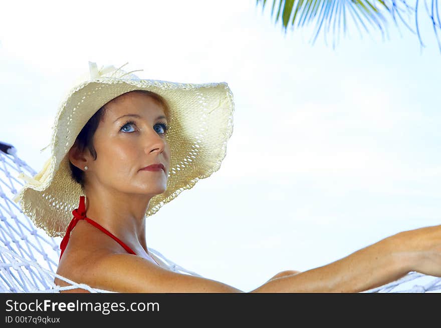 View of nice woman lounging in hammock in tropical environment. View of nice woman lounging in hammock in tropical environment