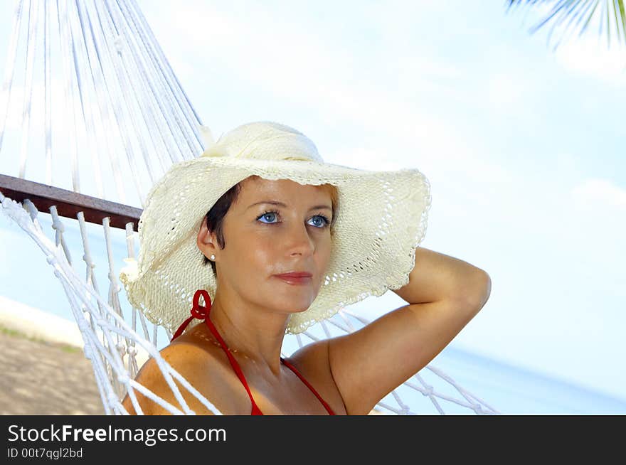 View of nice woman lounging in hammock in tropical environment