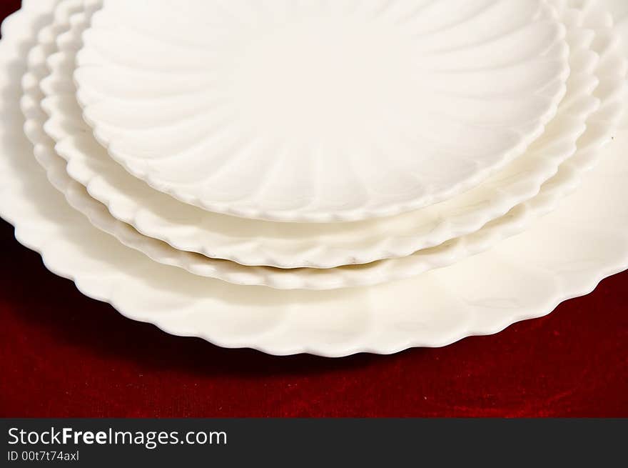 A shot of white plates isolated on red