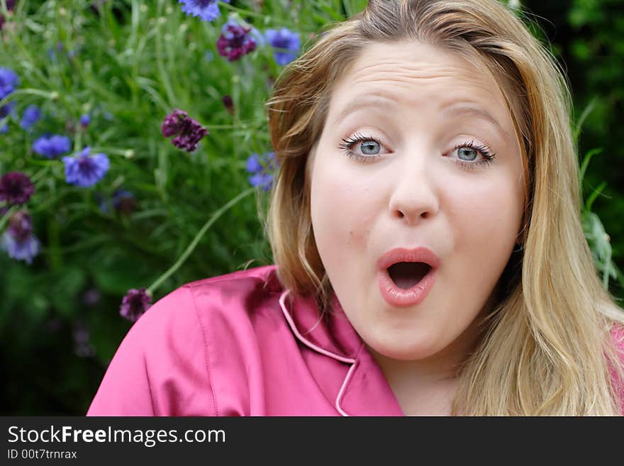 Caucasion female outdoors in her garden with a suprised expression on her face. Detailed close-up,. Caucasion female outdoors in her garden with a suprised expression on her face. Detailed close-up,