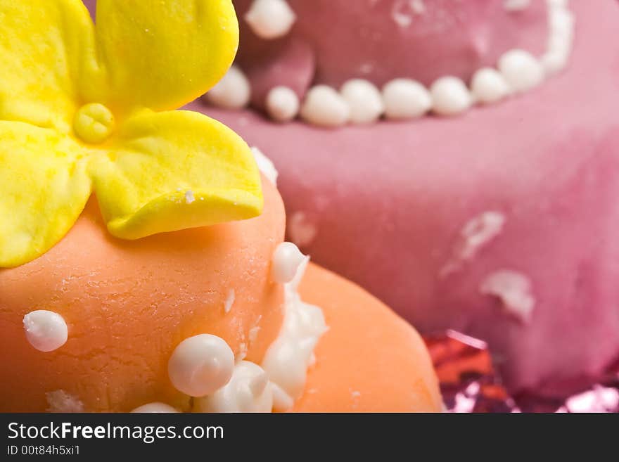 Two small nicely decorated cakes yellow and pink