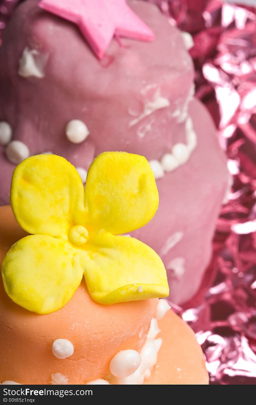 Two small nicely decorated cakes yellow and pink