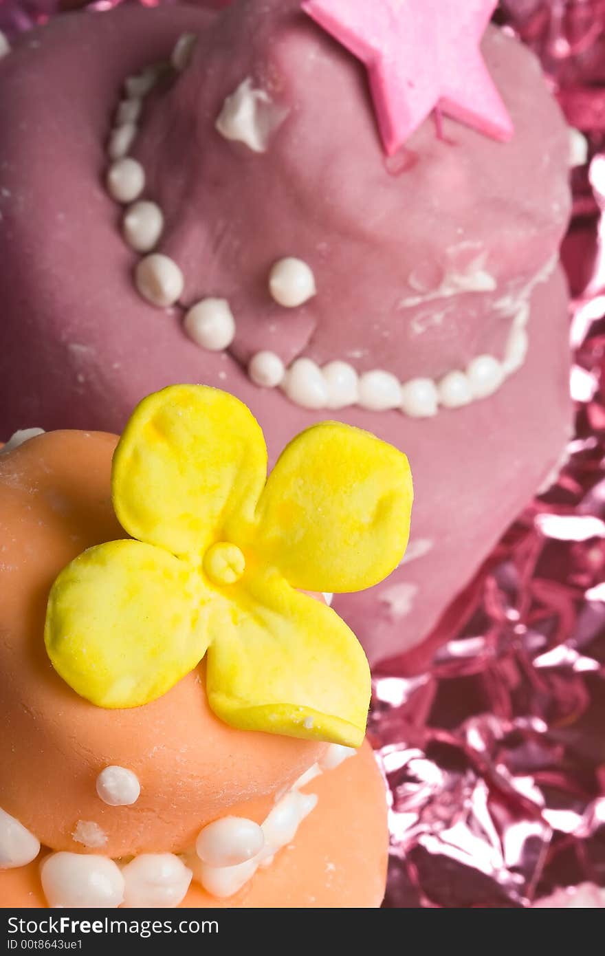 Two small nicely decorated cakes yellow and pink