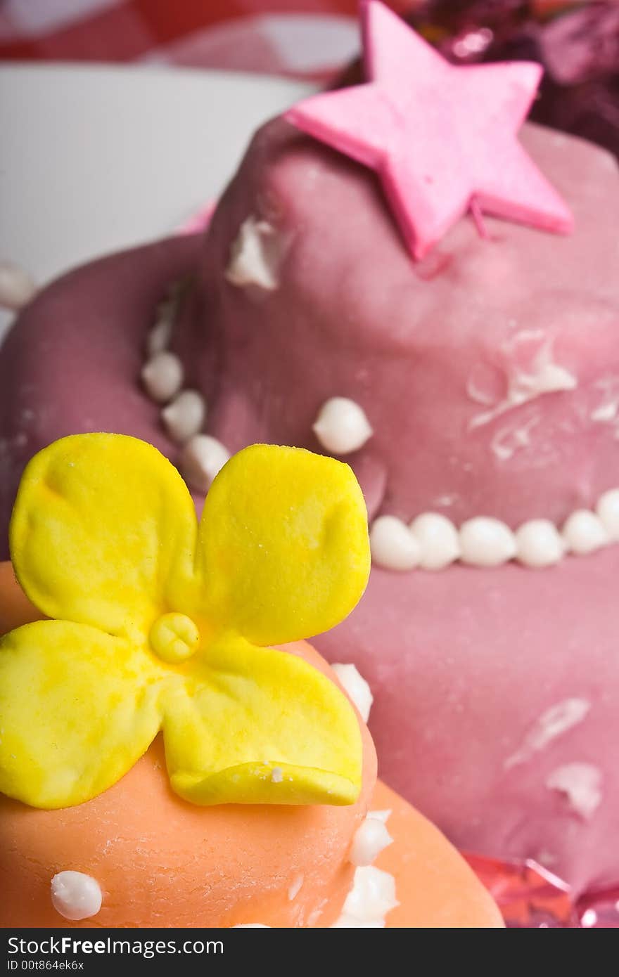 Two small nicely decorated cakes yellow and pink