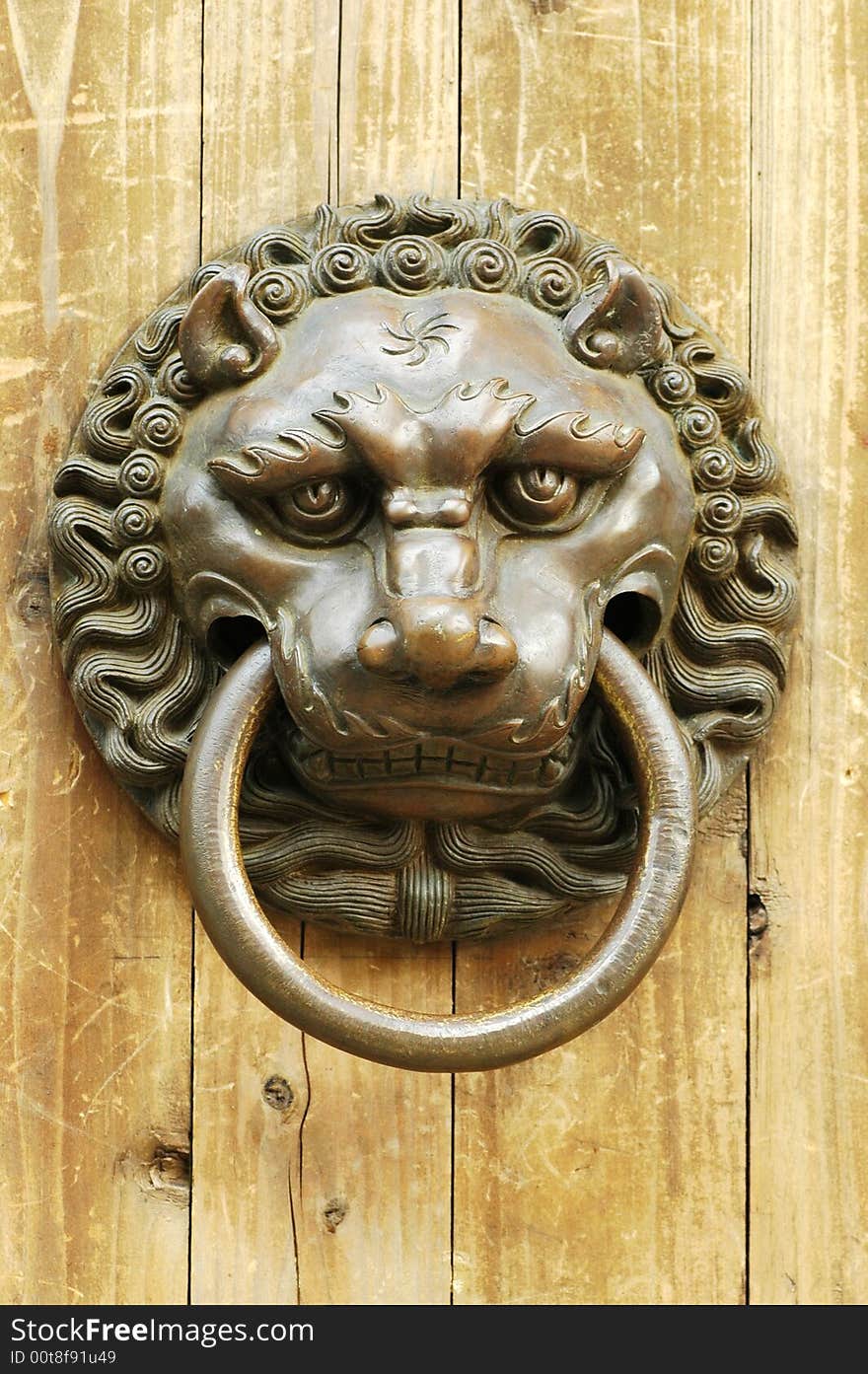 An ancient knocker withe a figure of lion. In ancient China, this kind of knocker were used on door for visitors to knock the door. It is made with some tigerish animal, which means it can deter the trespassers.