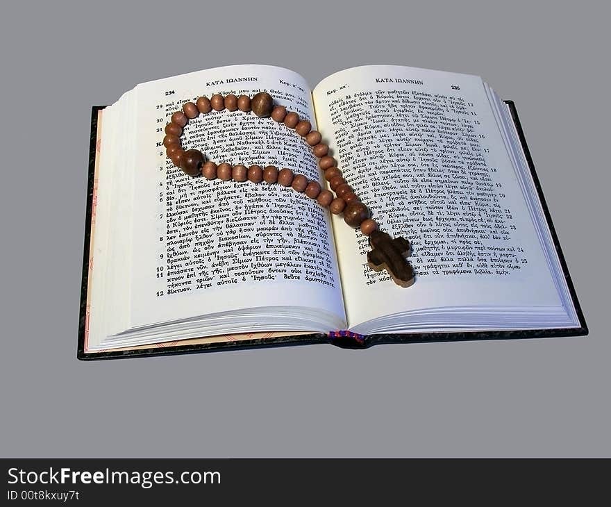 Little wooden rosary lying on open religious book. Little wooden rosary lying on open religious book