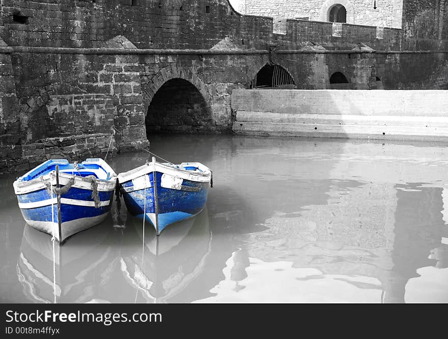 Black and white harbour with two blue boats