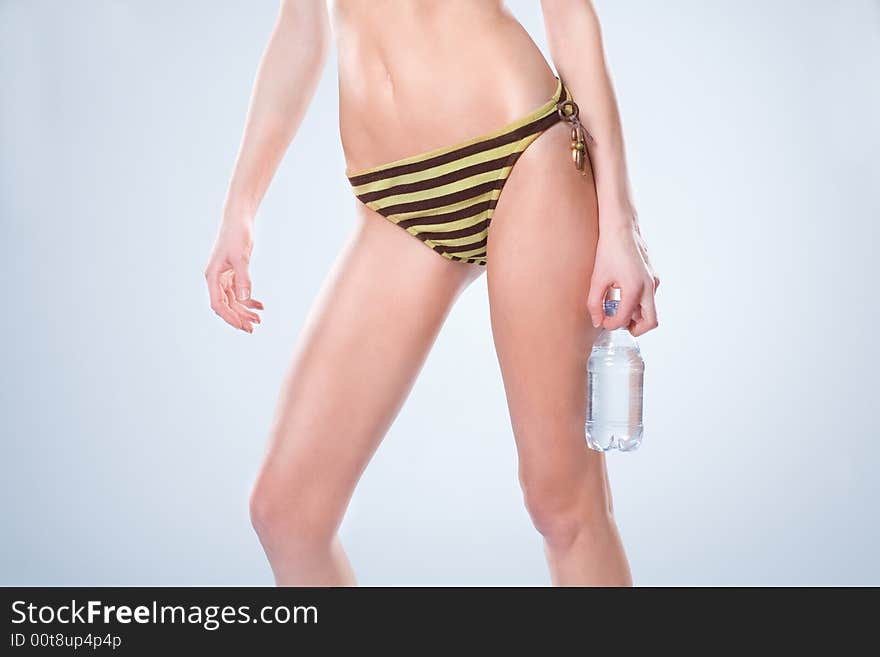 Woman wearing a swimsuit and holding a water bottl