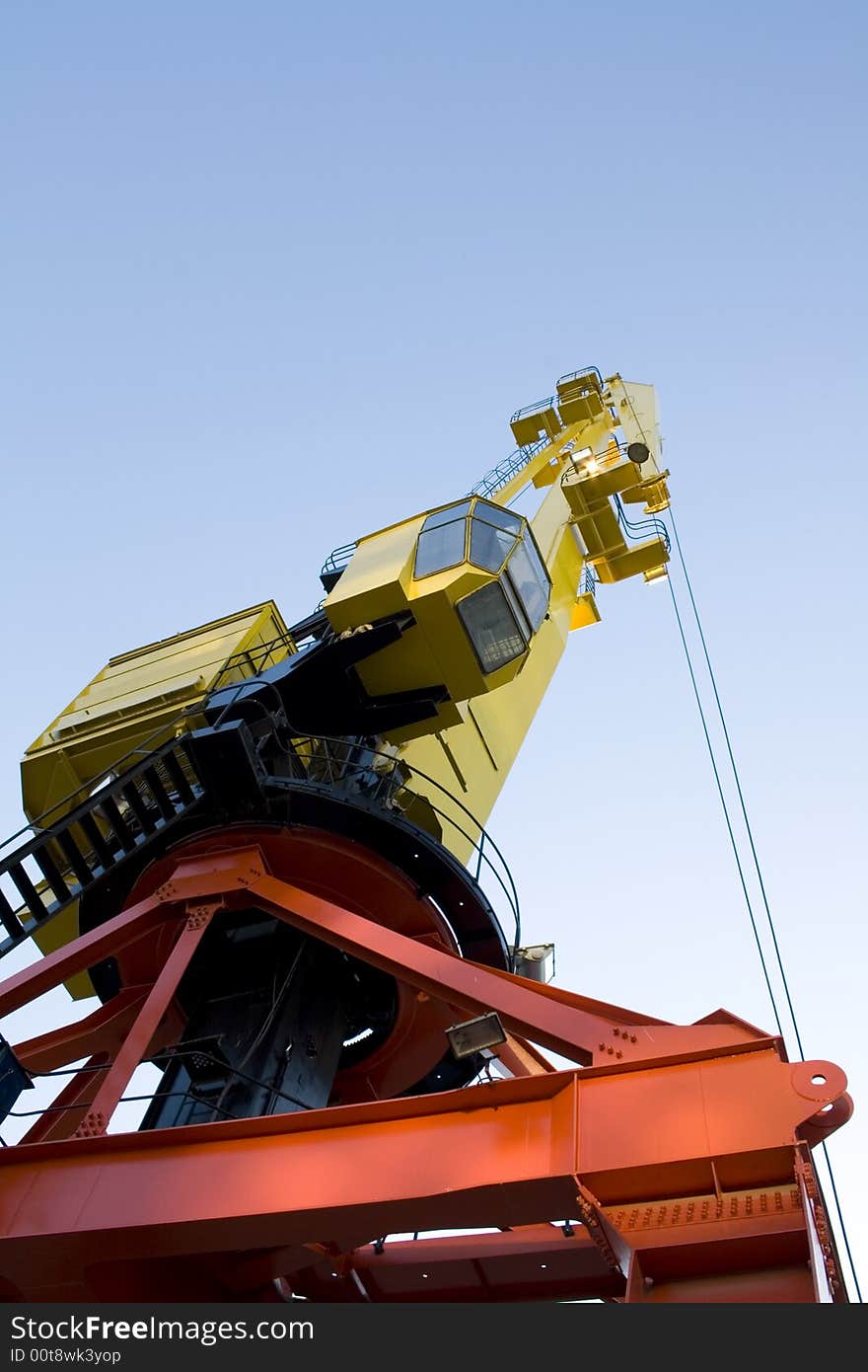 Heavy duty crane in yellow and orange. It has a copy space on top.