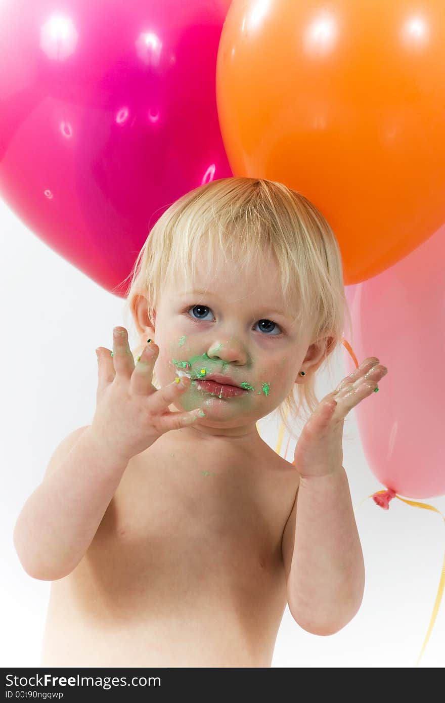 A little girls shows us her messy face and hands with balloons in the background. A little girls shows us her messy face and hands with balloons in the background