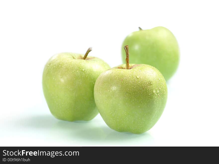 The ripe juicy apples covered by drops of water. Isolation on white, shallow DOF. The ripe juicy apples covered by drops of water. Isolation on white, shallow DOF