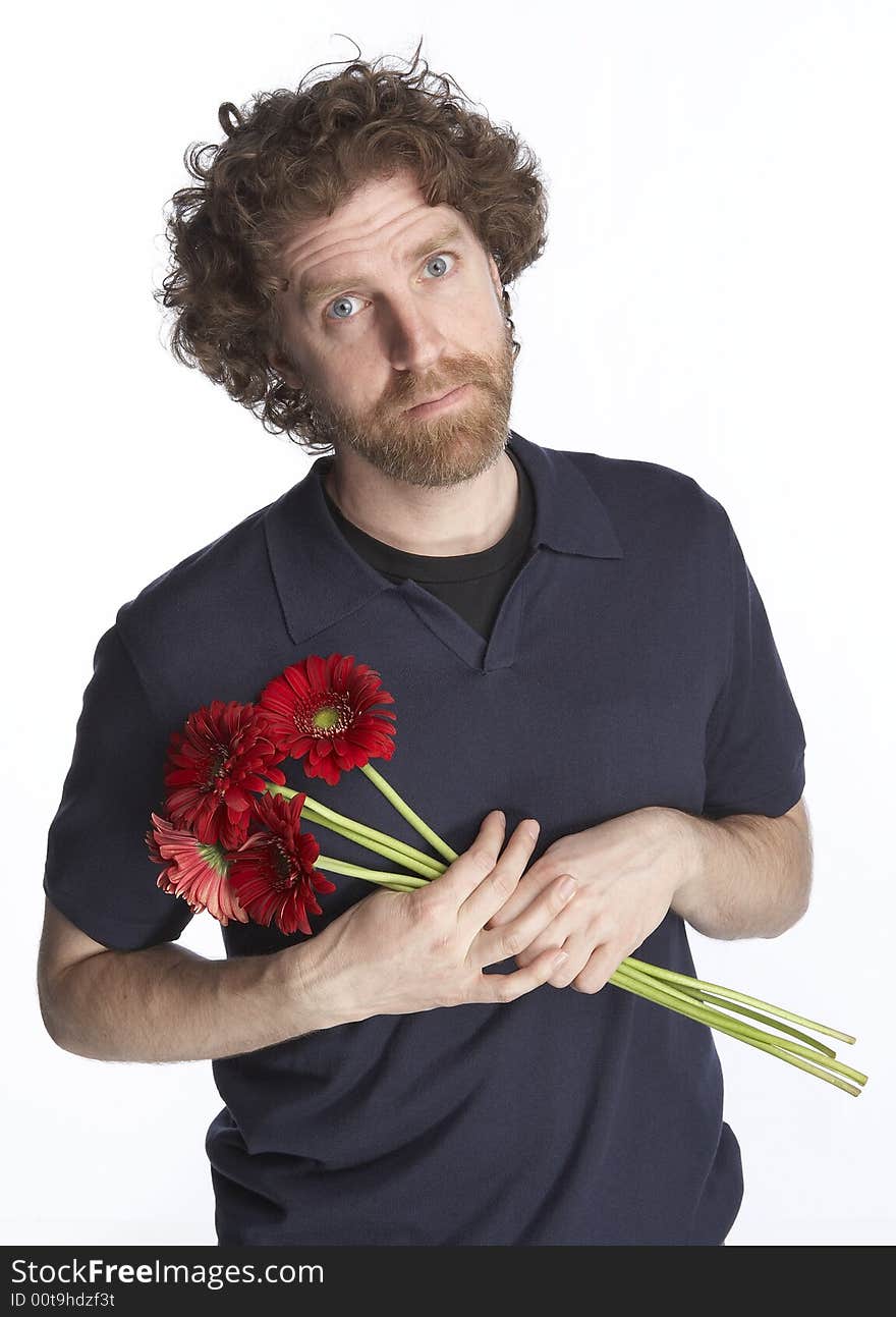 Man holding a bunch of flowers and looking apologetic. Man holding a bunch of flowers and looking apologetic