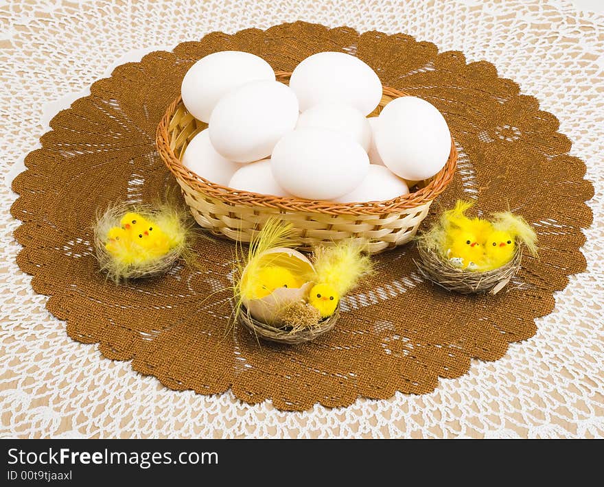 A basket of eggs and a group of easter chickens