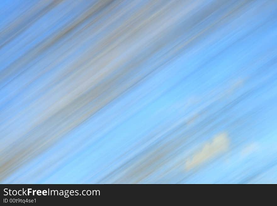 Abstract motion blur of Autumn trees and blue sky from a moving vehicle. Abstract motion blur of Autumn trees and blue sky from a moving vehicle