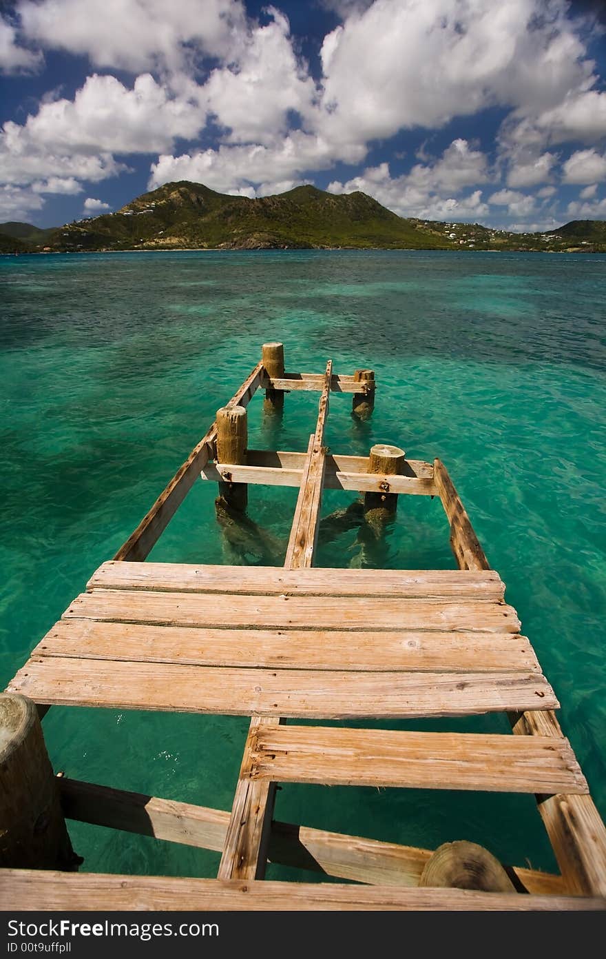 Damaged dock over turquoise waters on tropical island. Damaged dock over turquoise waters on tropical island