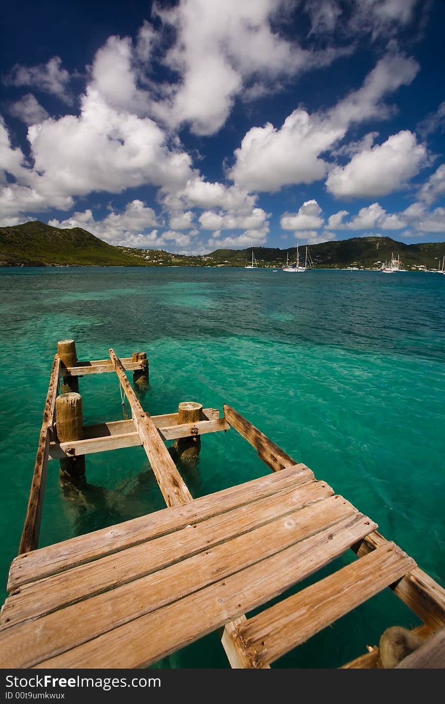 Damaged dock over turquoise waters on tropical island. Damaged dock over turquoise waters on tropical island