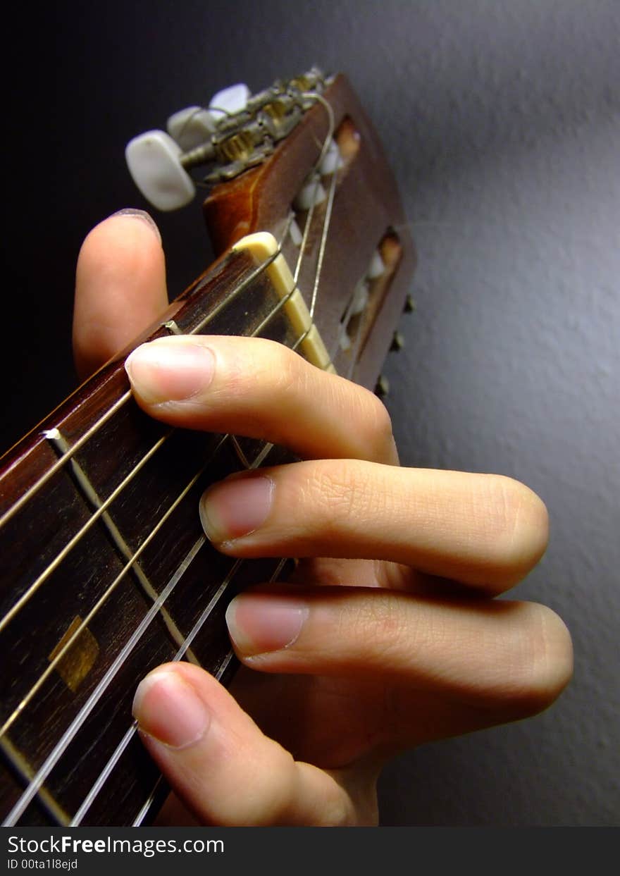 Fingers picking chord on acoustic guitar neck, playing the chord D/F#