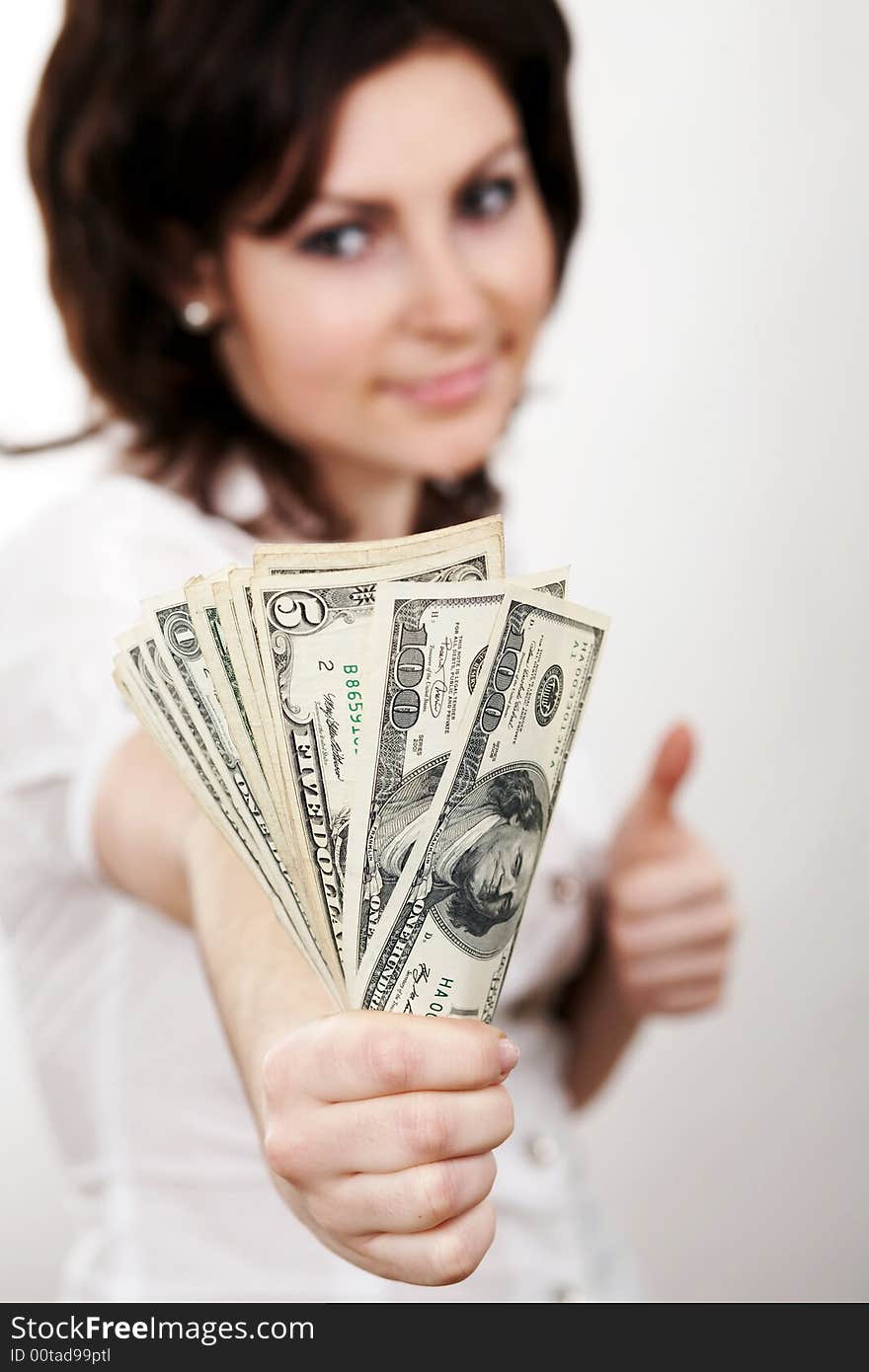 A girl in a white blouse with dollars in her hand. A girl in a white blouse with dollars in her hand