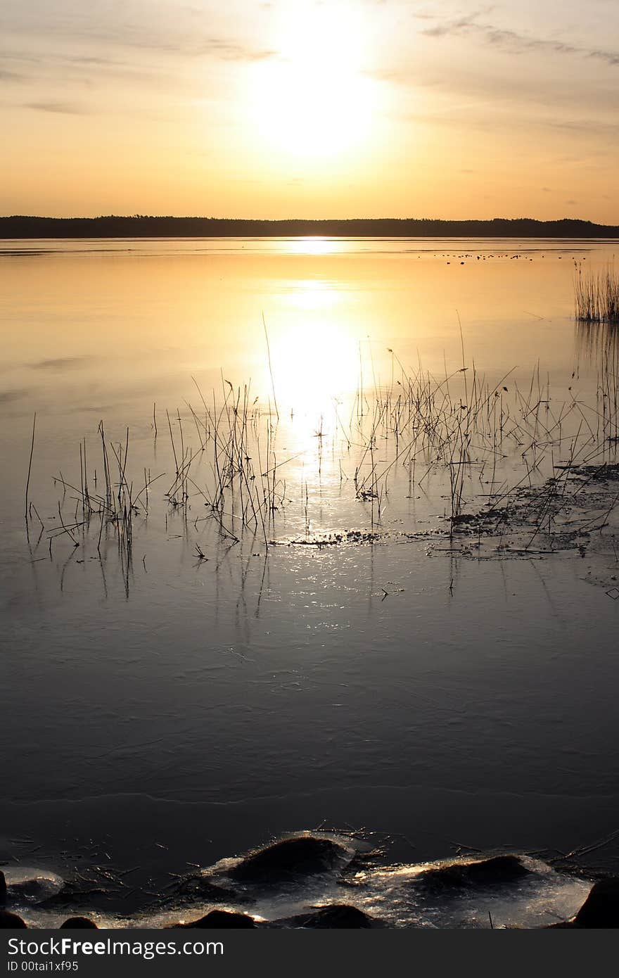 Sunrise over lake with ice in the winter