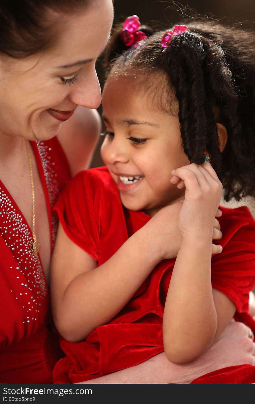 Beautiful multiracial child with afro hairstyle playing with her mother. Beautiful multiracial child with afro hairstyle playing with her mother