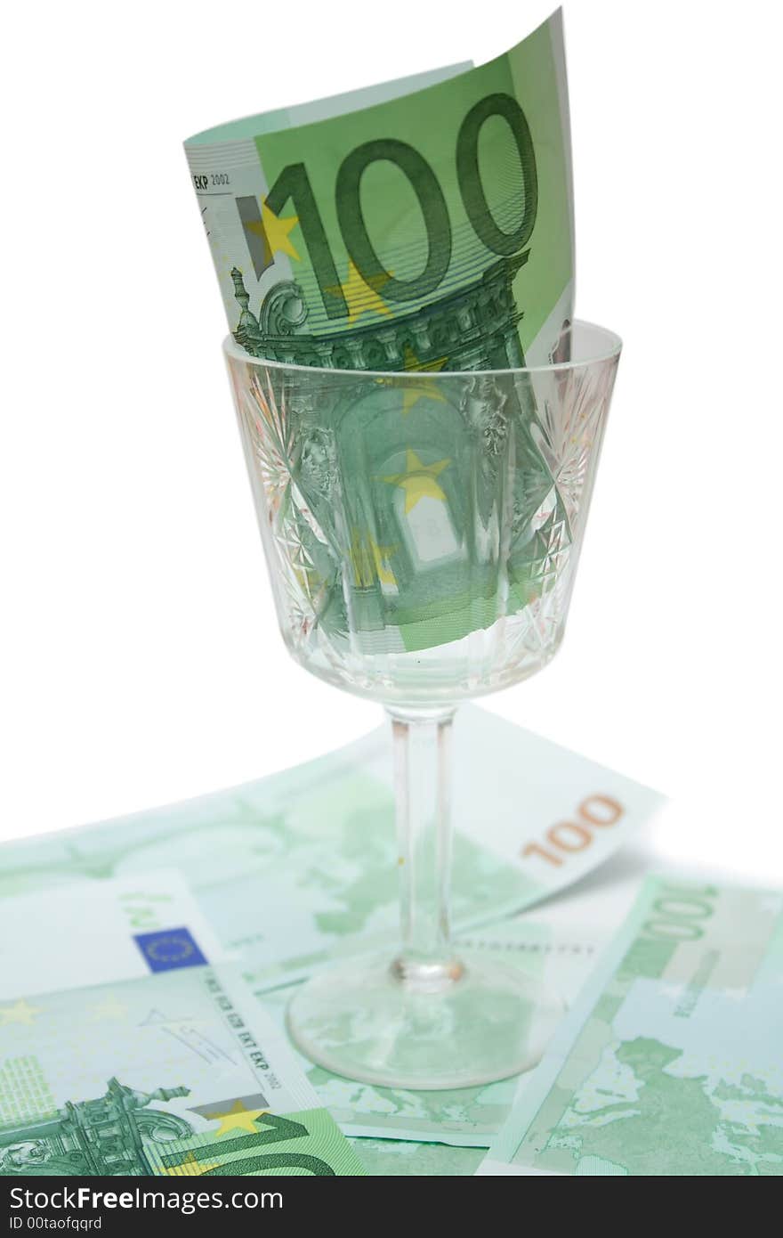 One 100 euro banknote in wineglass over white isolated background