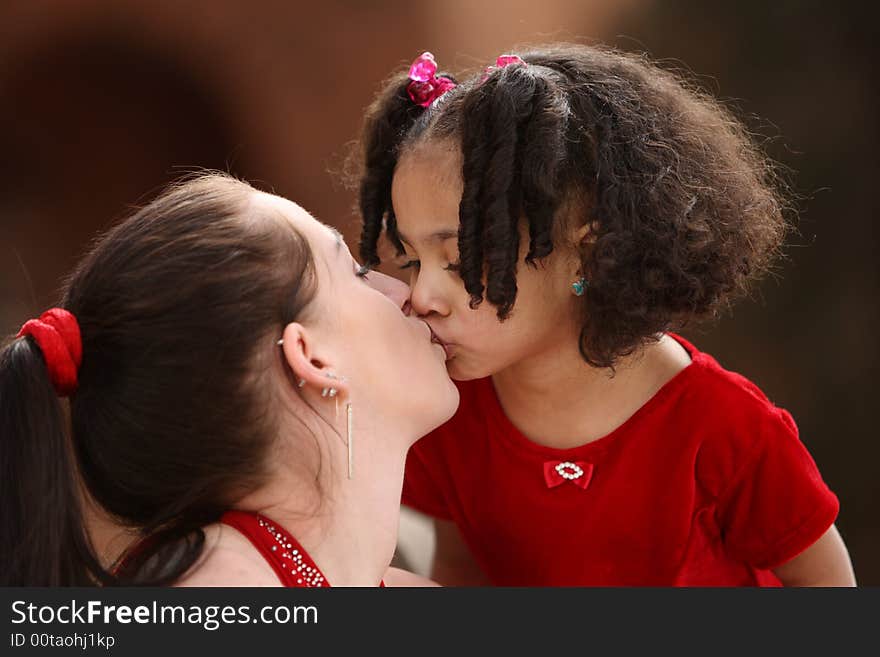 Beautiful multiracial child with afro hairstyle playing with her mother. Beautiful multiracial child with afro hairstyle playing with her mother