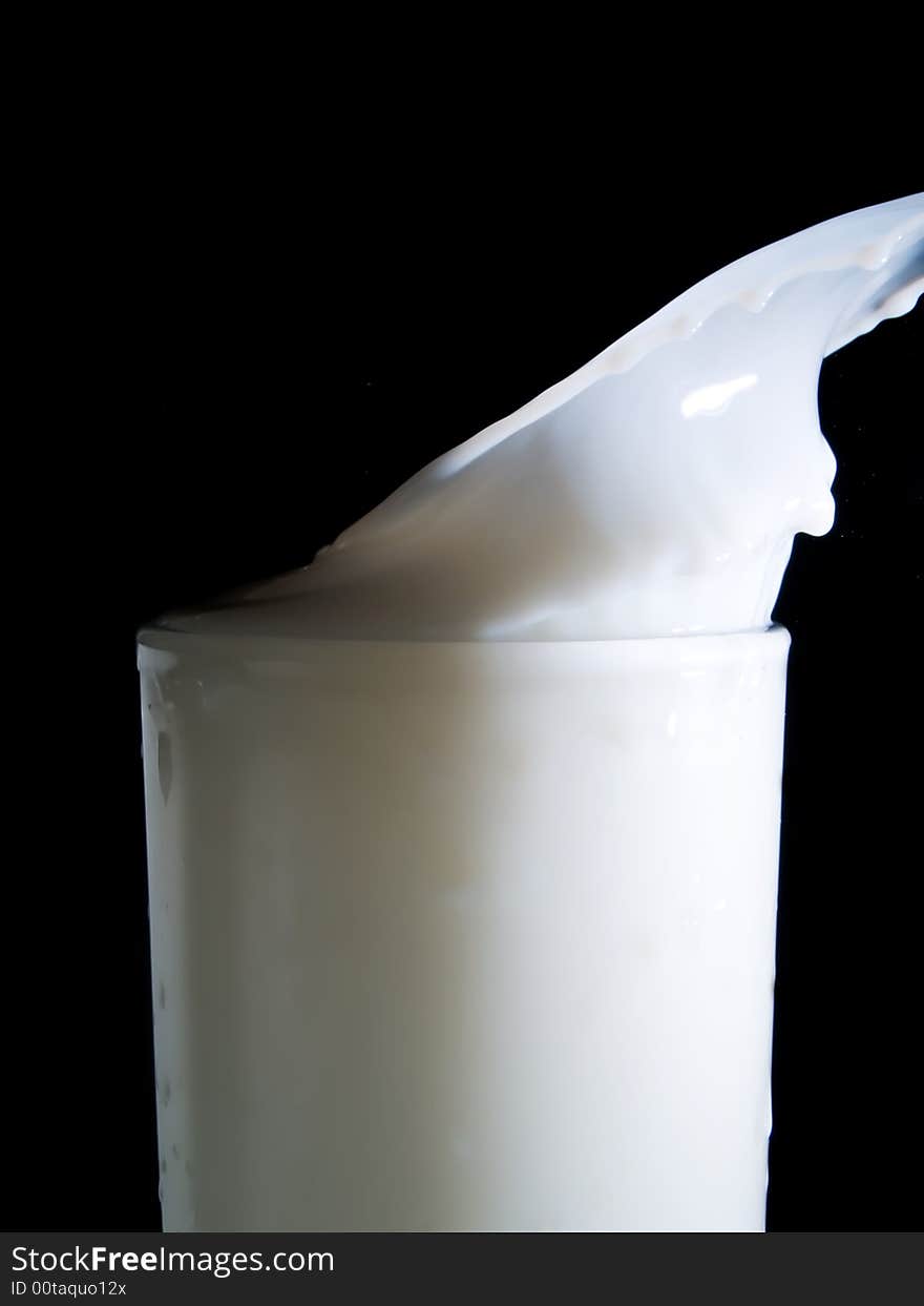 Glass of milk on a black background