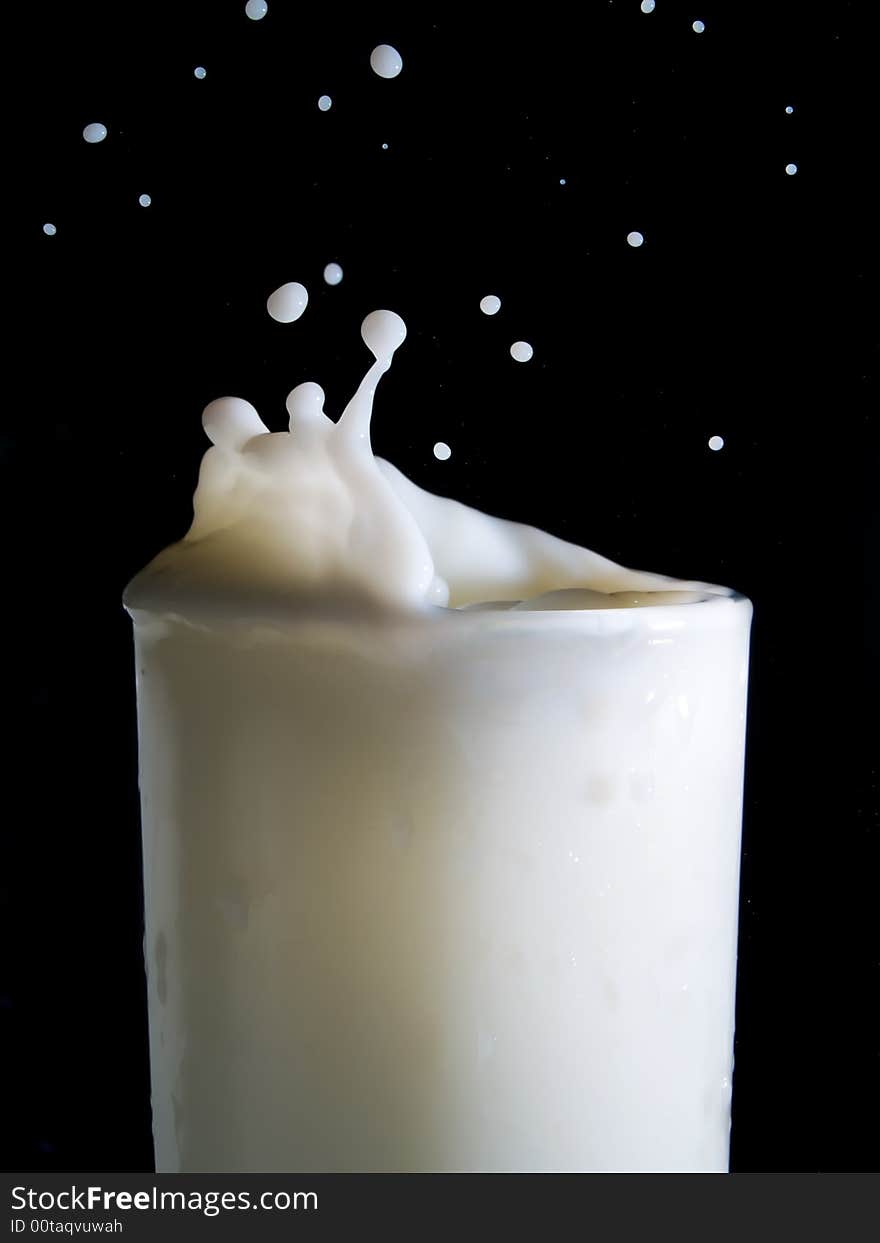 Glass of milk on a black background